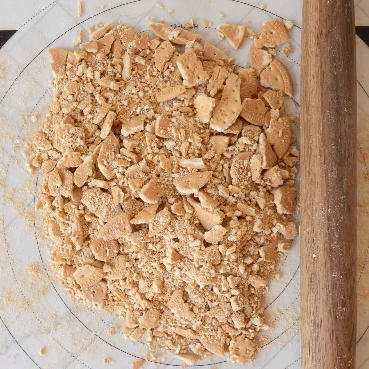 Crushing marie biscuits with a rolling pin, to make an easy chocolate hedgehog slice.