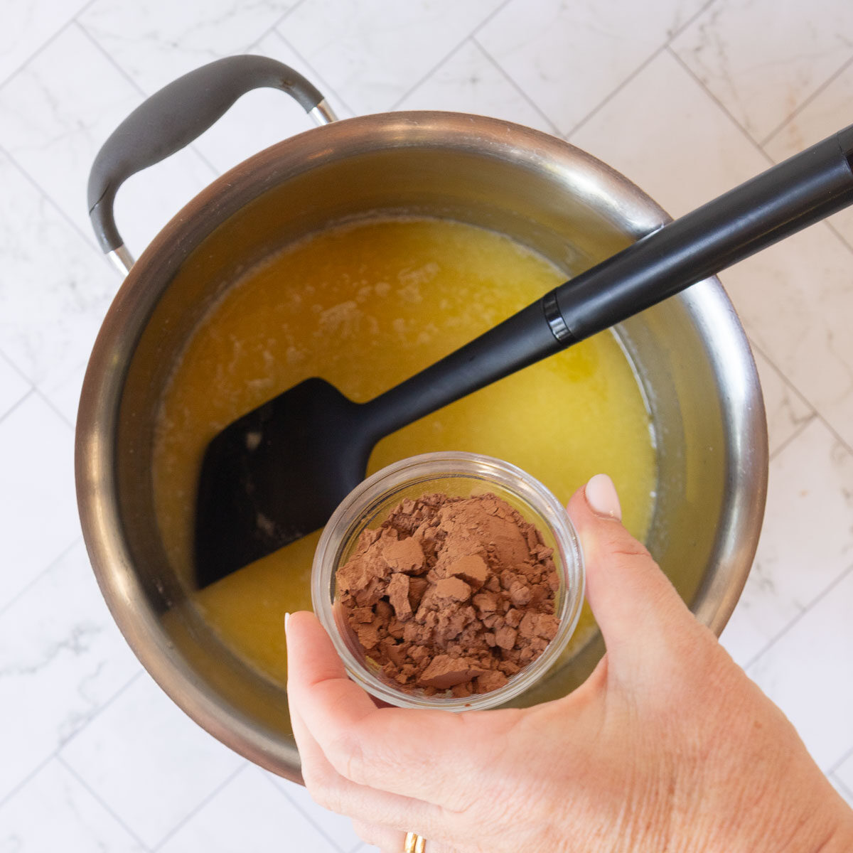 Adding cocoa to the melted butter, to make the base of the hedgehog slice.