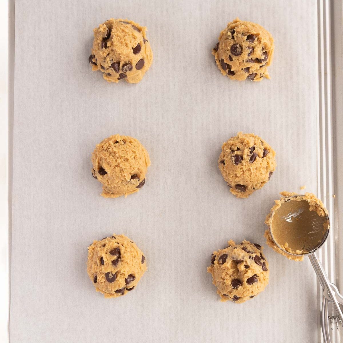 Scooping out cookie dough to make no chill chocolate chip cookies.