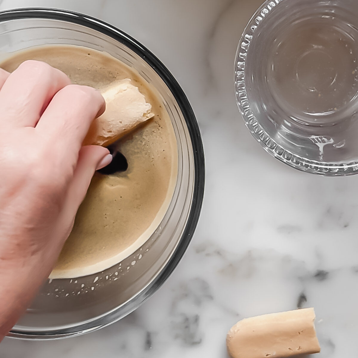Dipping ladyfinger biscuits into espresso to make tiramisu.