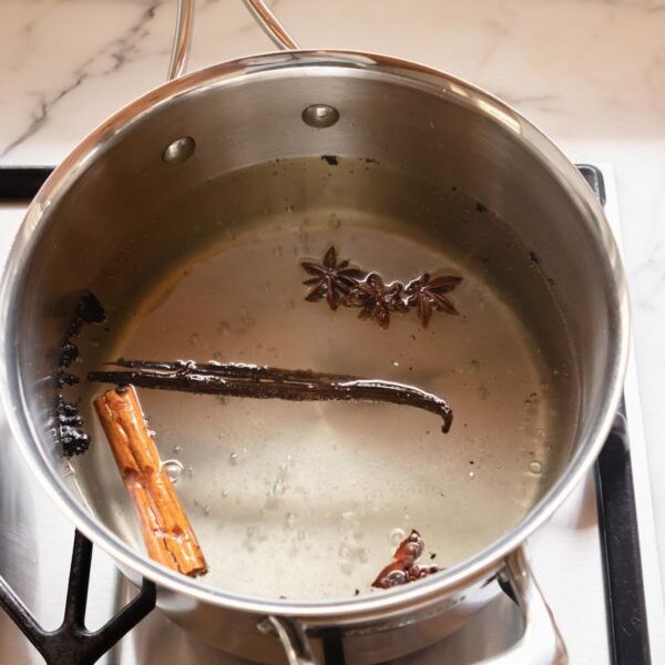 Making the poaching liquid for pears, using vanilla bean, star anise  and cinnamon stick