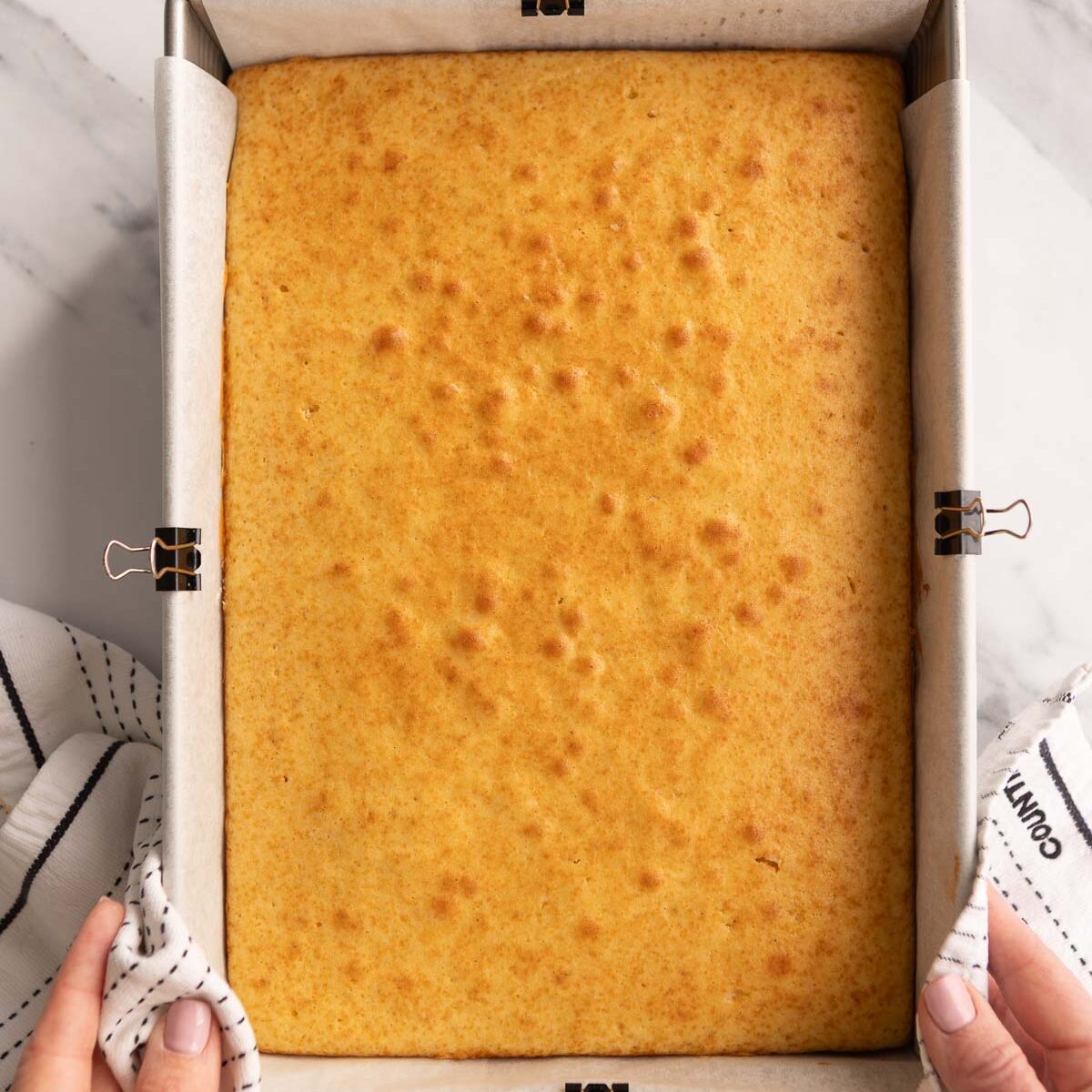 A vanilla sheet cake that has been baked until golden.