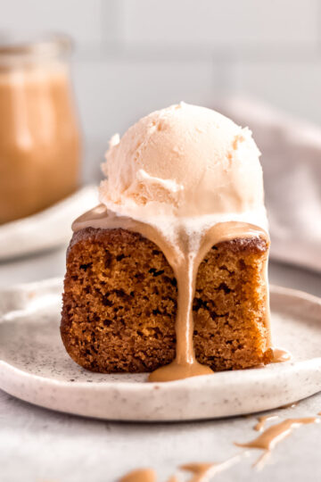 A square of sticky date pudding, topped with vanilla ice cream and rich butterscotch sauce.