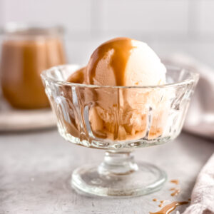 Rich and fudgy butterscotch sauce poured over vanilla ice cream.