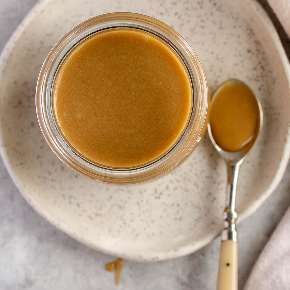 Butterscotch sauce poured into a glass jar.