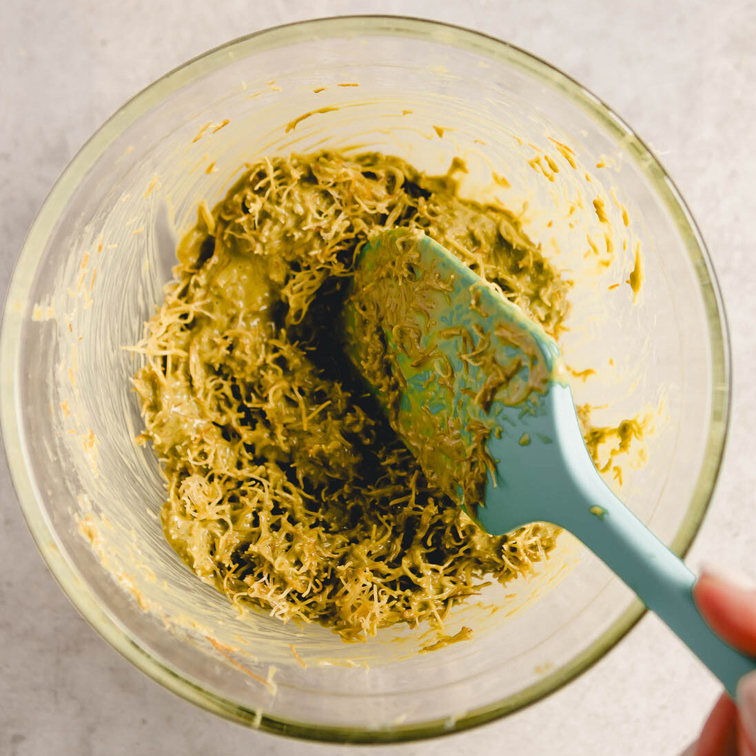 Mixing kataifi pastry with istachio cream.