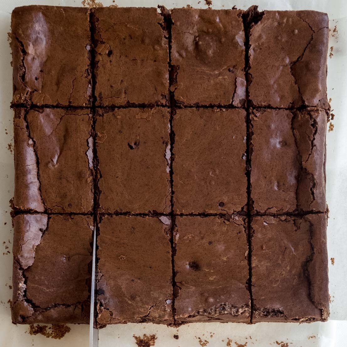 Cutting cooked fudgy brownies into bars.