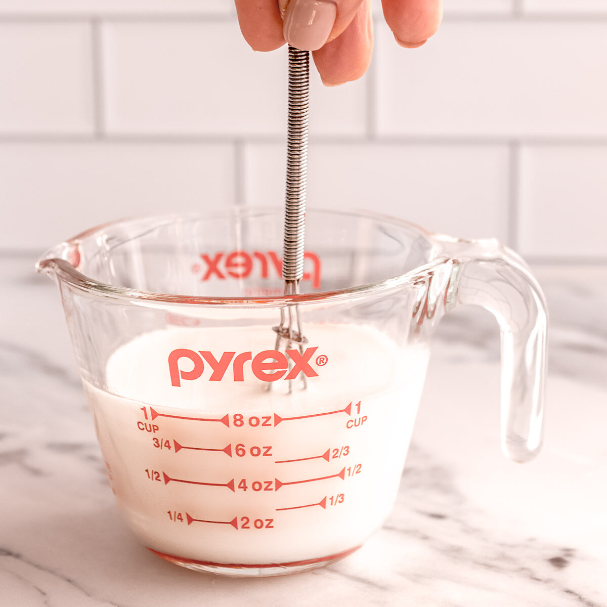 Gently stirring the vinegar and milk to a make buttermilk substitute at home.