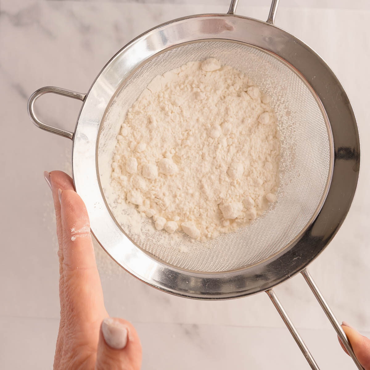 Sifting the 2 flours to make cake flour.