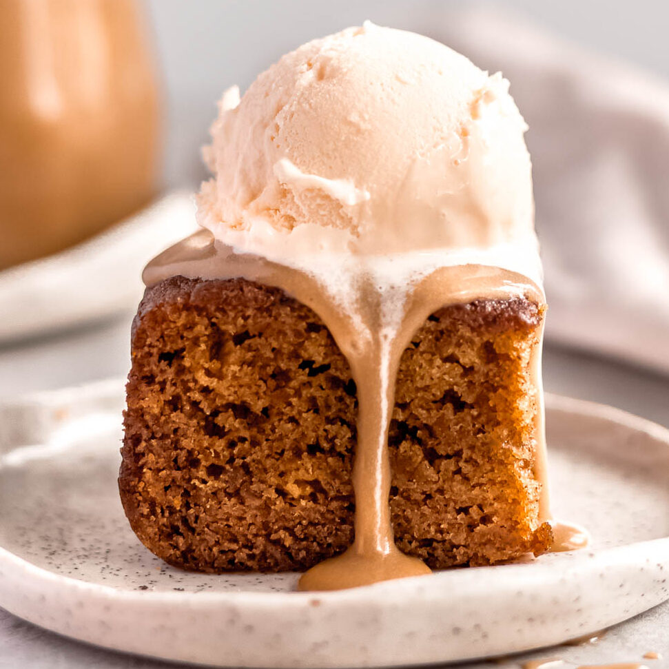A square of sticky date pudding with ice cream and butterscotch sauce.