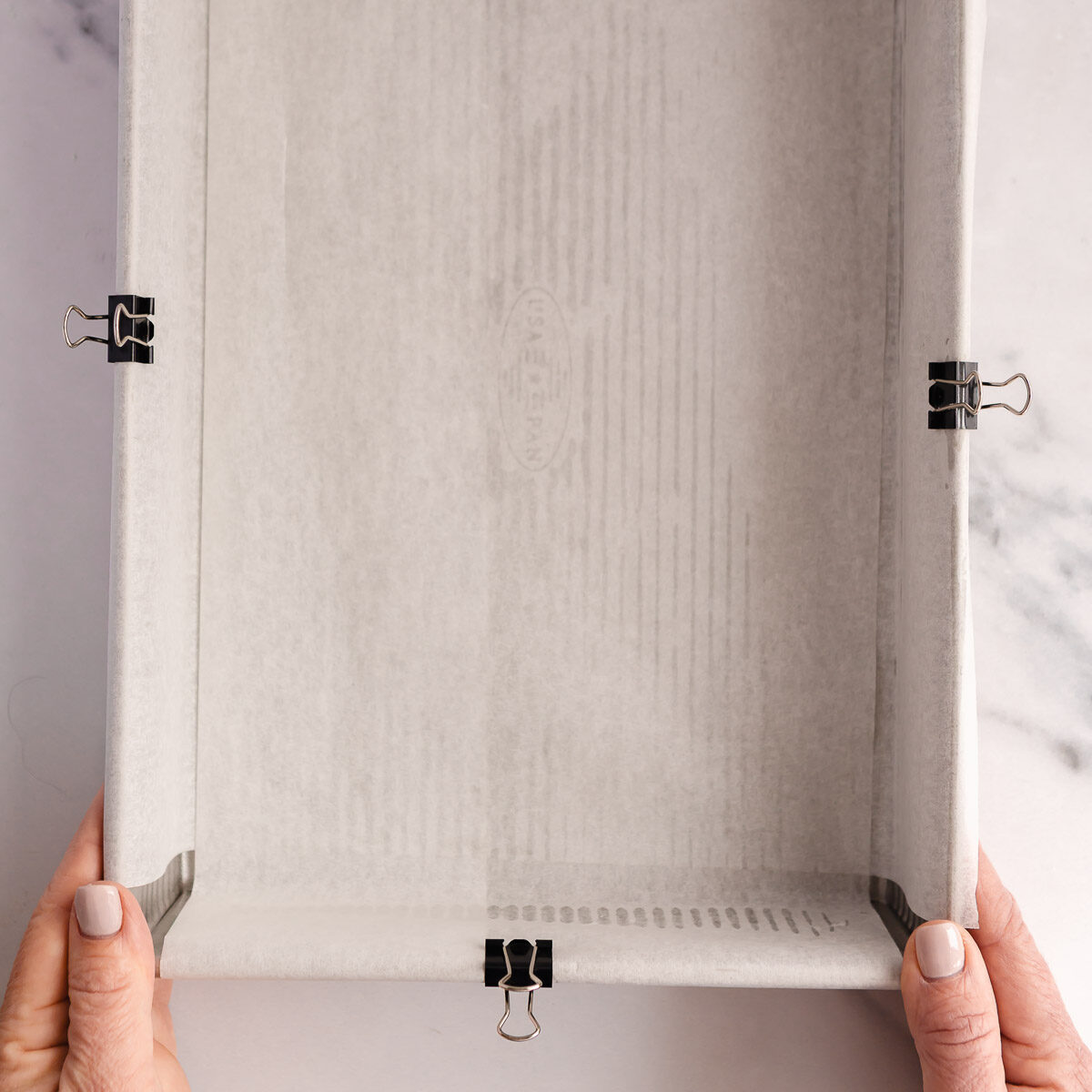 Lining a rectangle baking pan with baking paper.