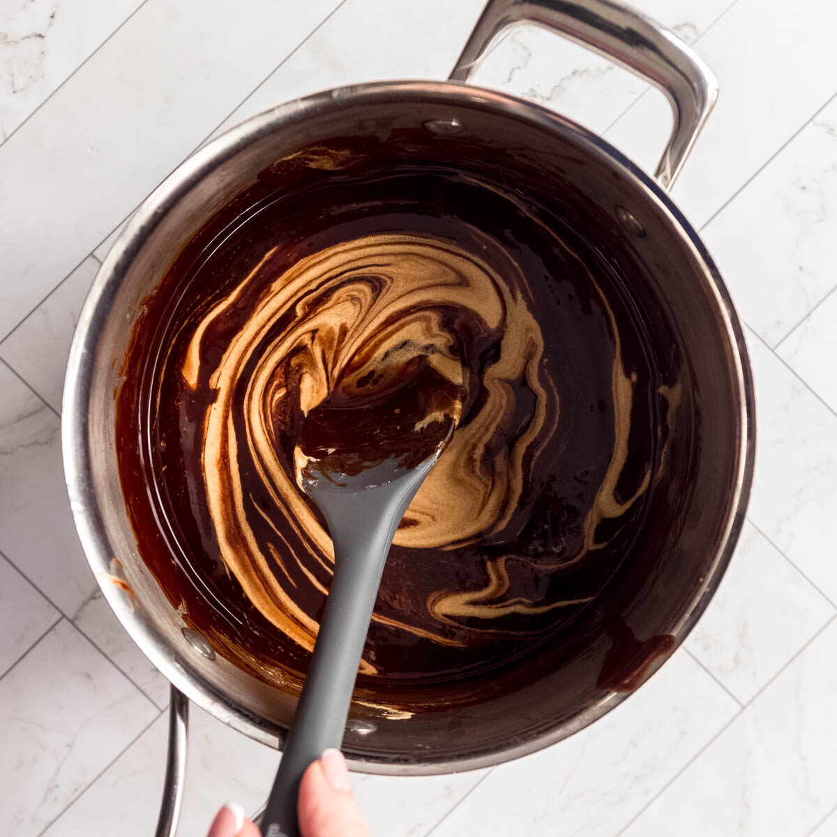 Adding the combined egg yolks and sugar to the chocolate mixture.