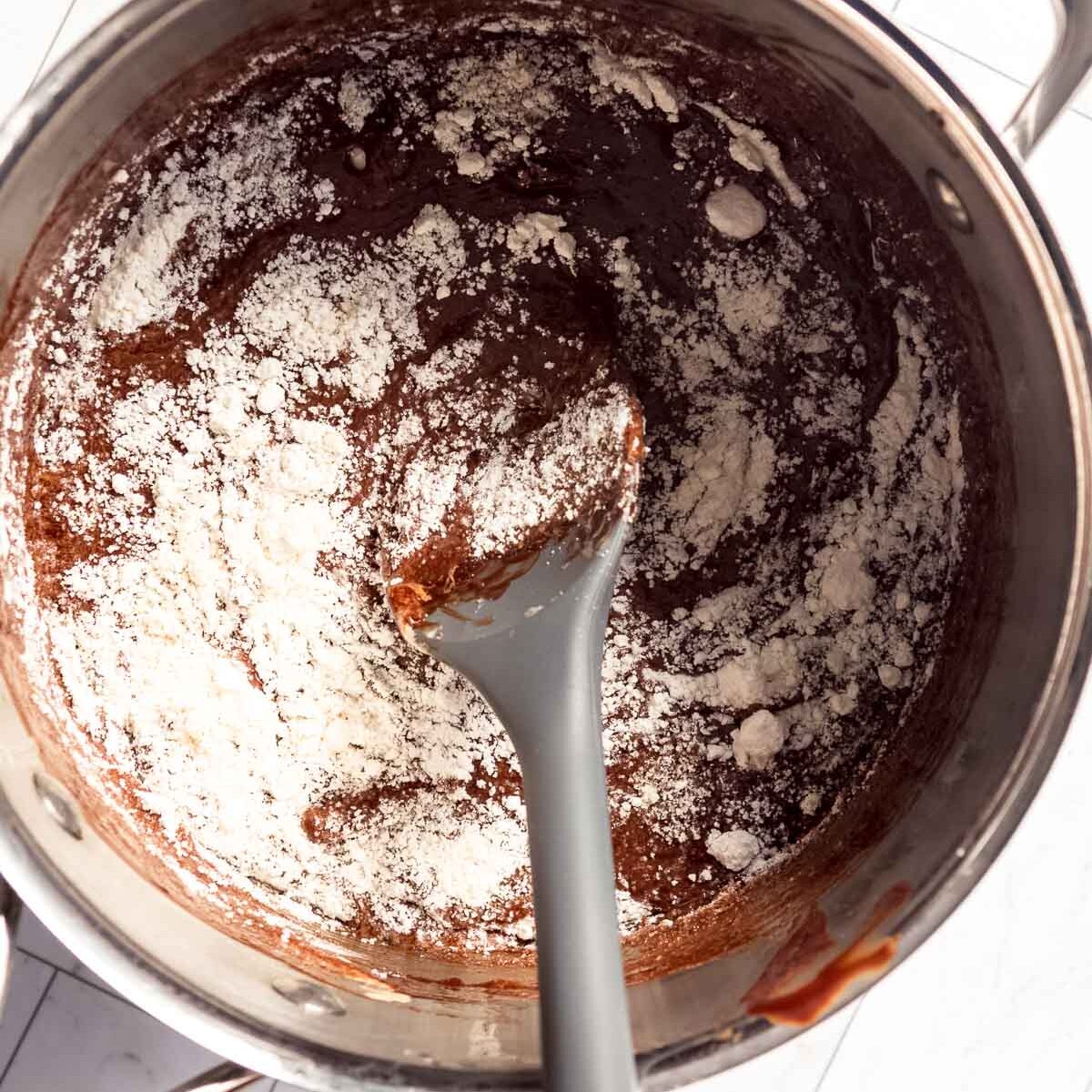 How to make a chocolate fudge cake: adding the flour and almond meal to the chocolate mixture.