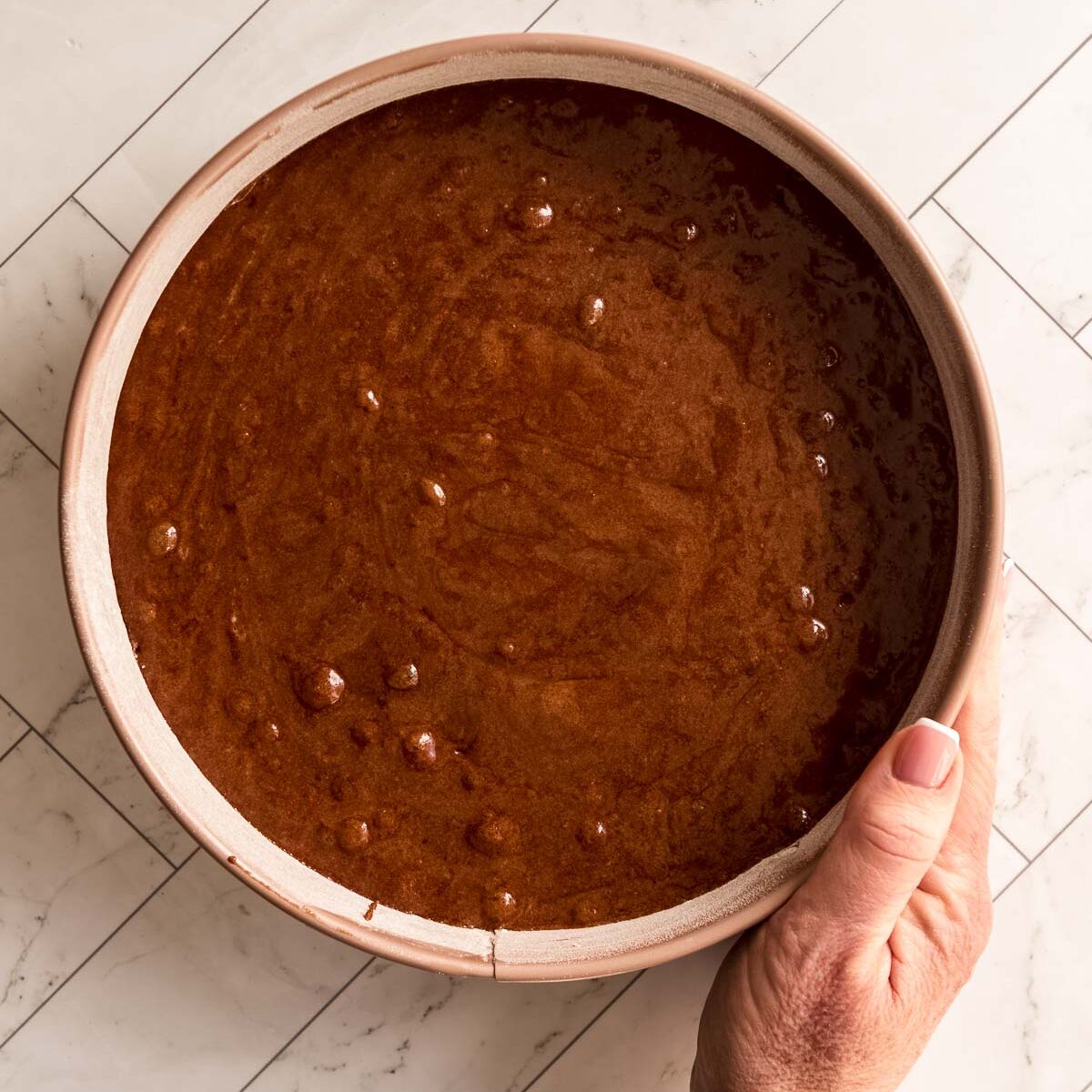 Chocolate fudge cake batter poured into a prepared 23cm springform tin.