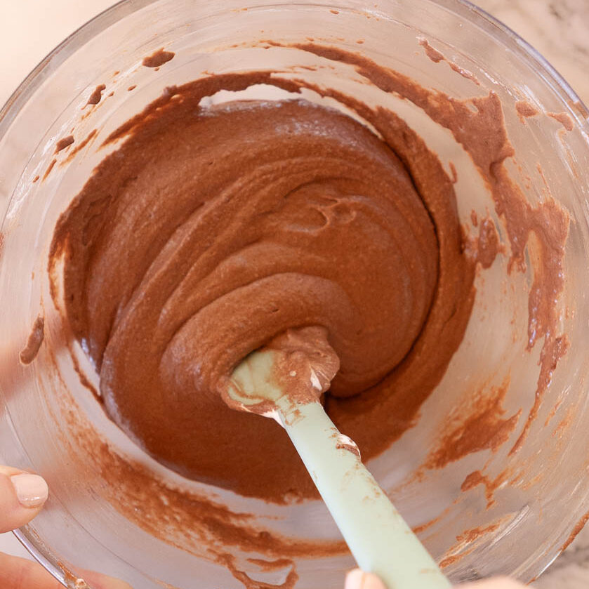 Mixing the macaron mixture until smooth.