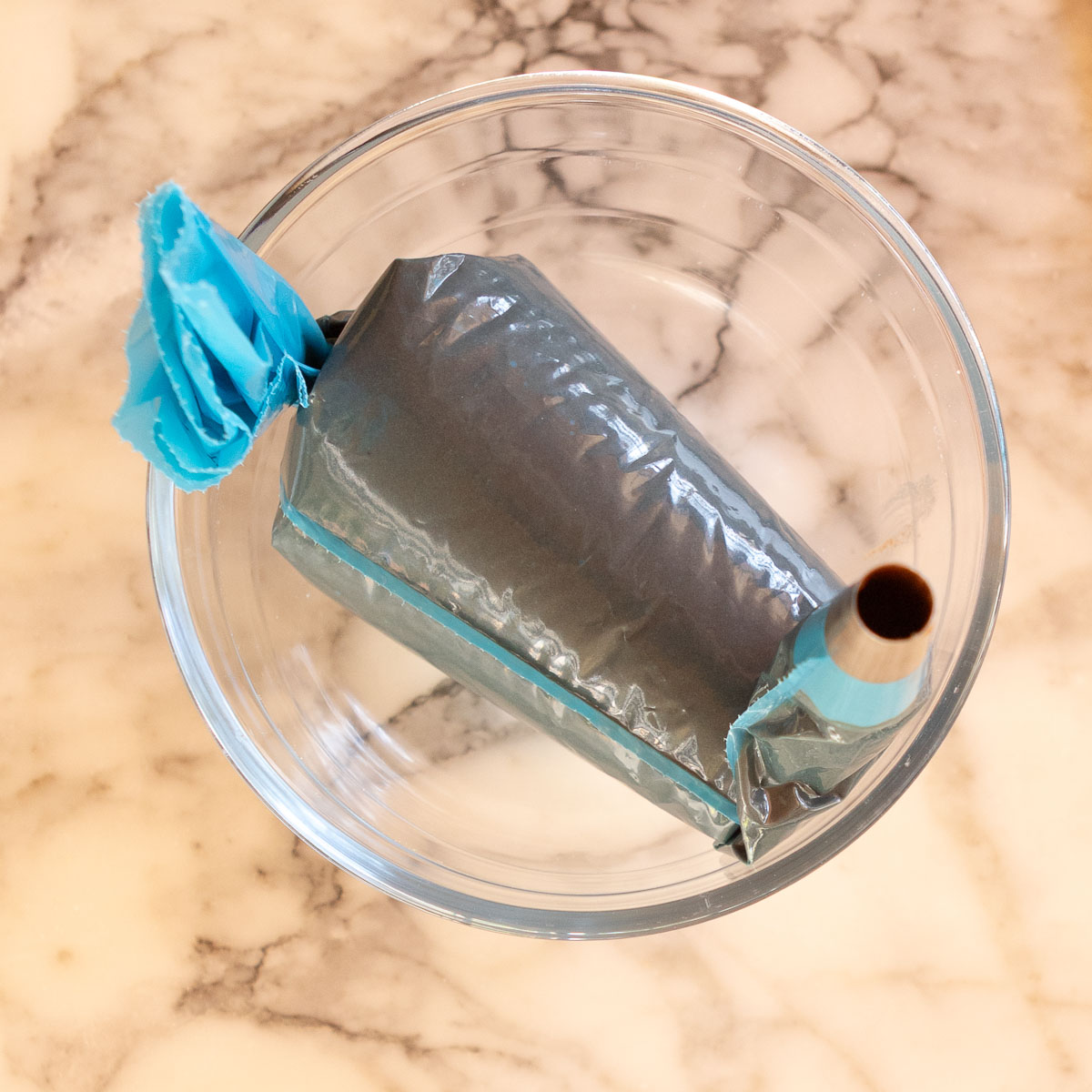 Resting the piping bag in a bowl, to avoid mixture seeping out.