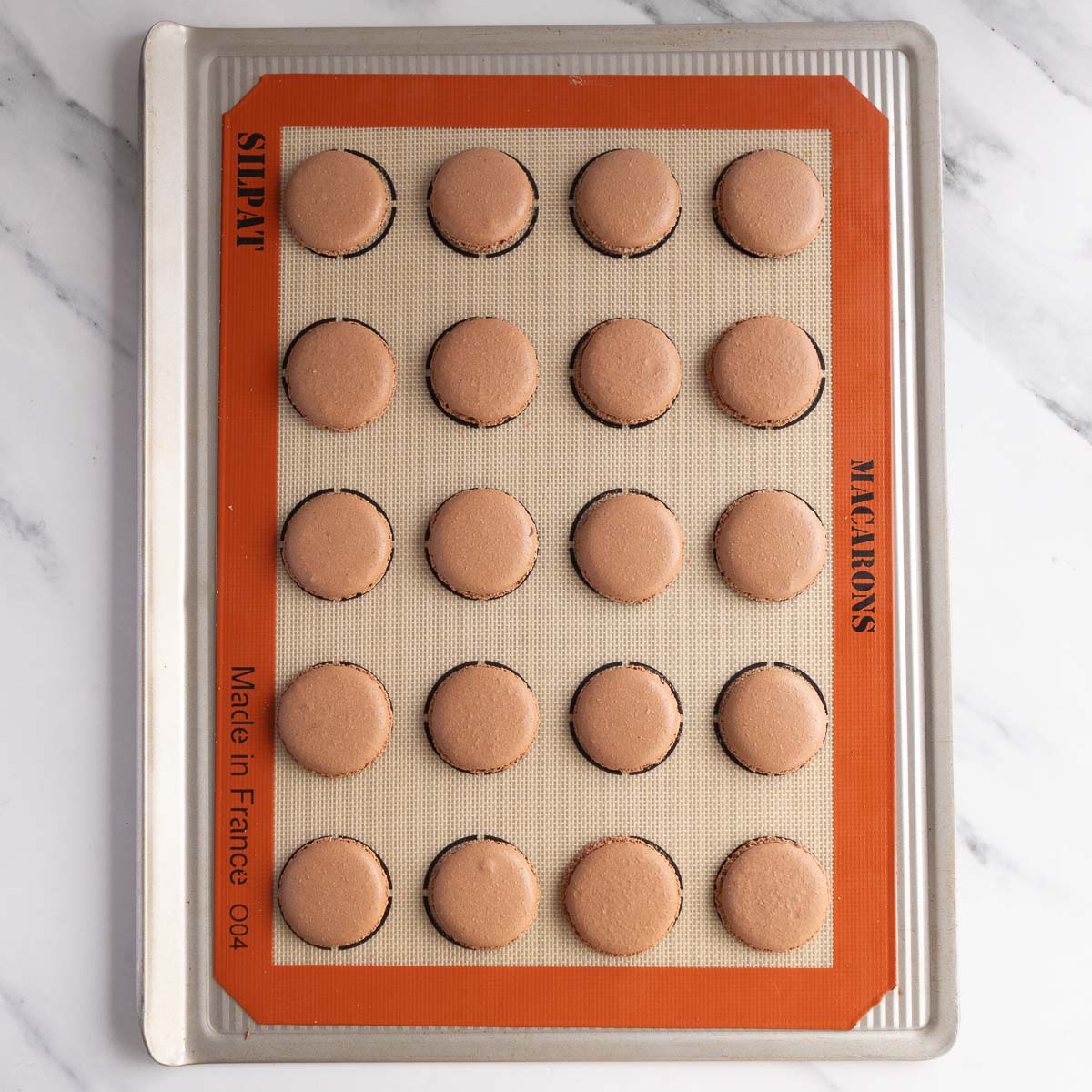 Baked macaron shells with perfect feet.