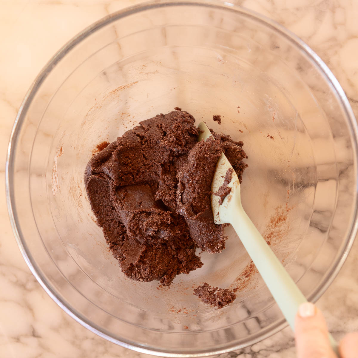 Mixing egg whites and dry ingredients to form a paste.