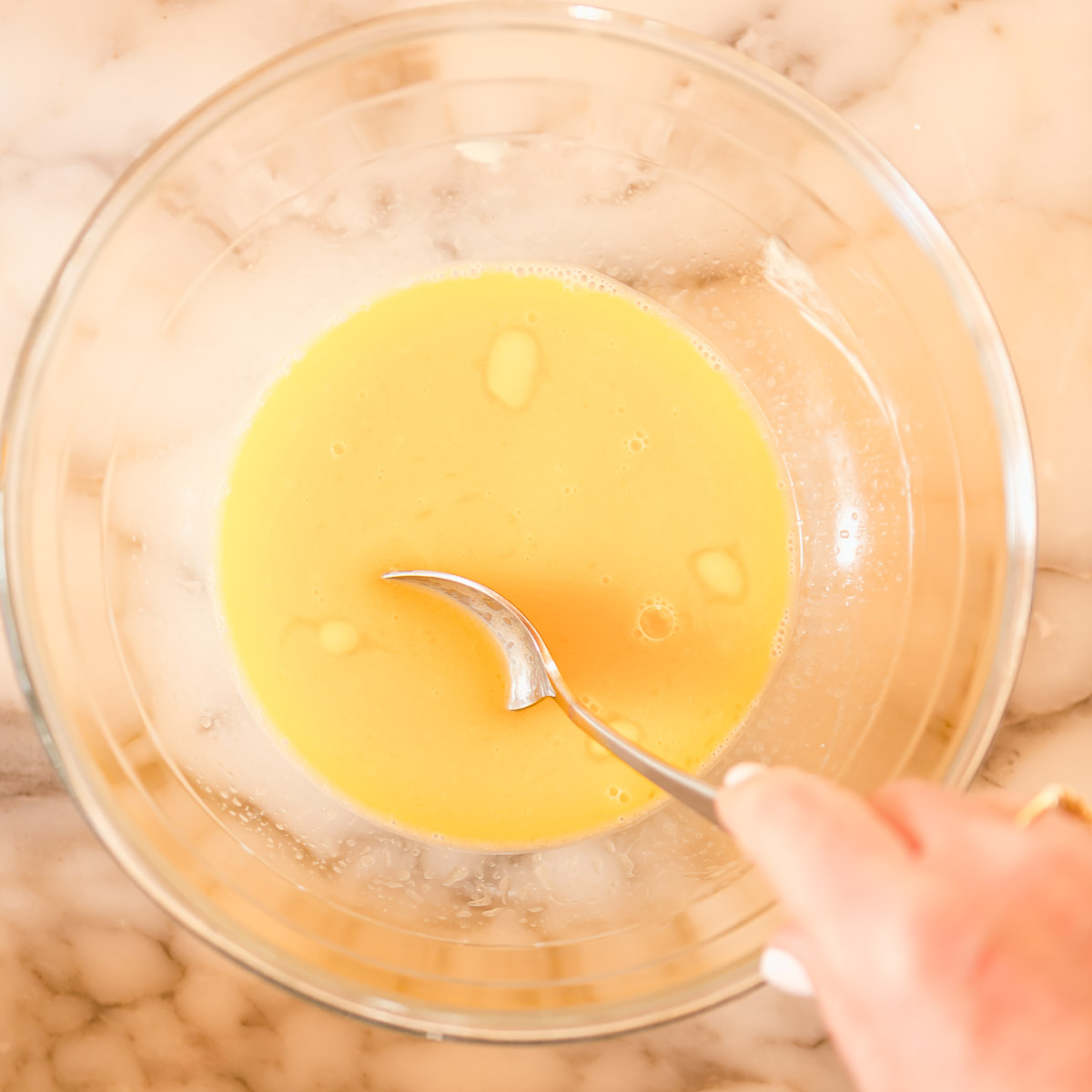 Melting the butter in hot milk.