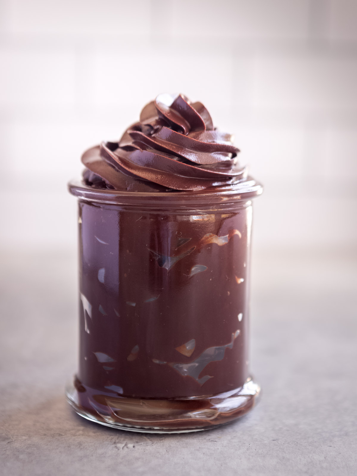 A glass jar filled with dark chocolate ganache.