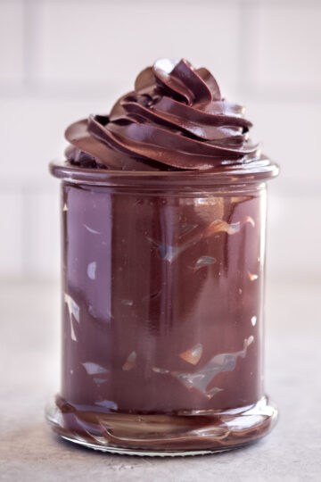 A glass jar, filled with swirls of piped chocolate ganache.