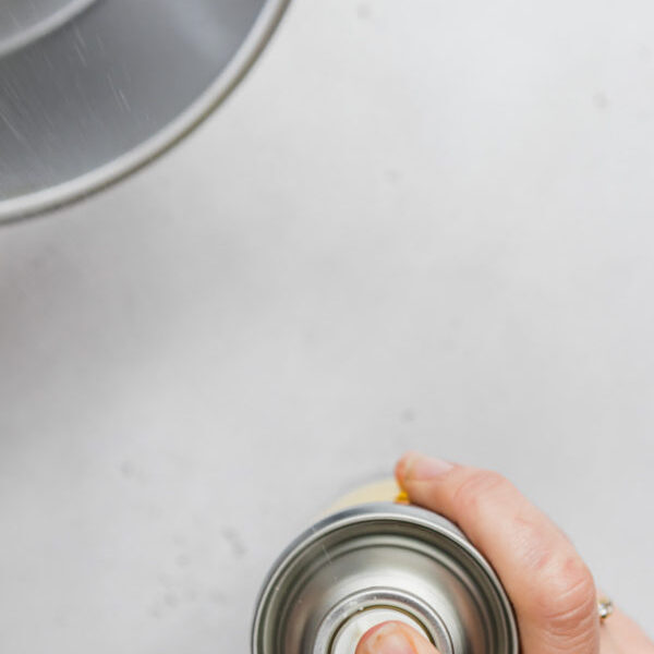 Spraying cake tin with oil.