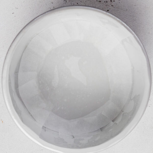 Finish lining the cake tin with a disc of baking paper.