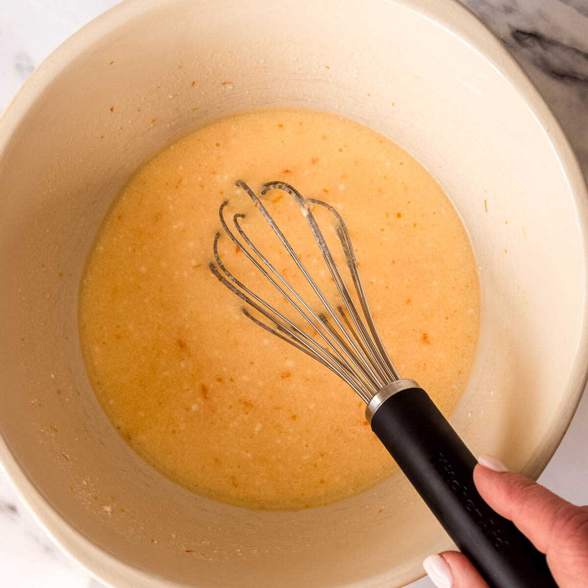 Whisking the wet ingredients to make a citrus cake.