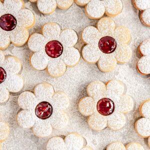 Pretty Linzer cookies, made in the shape of a daisy and filled with raspberry jam.