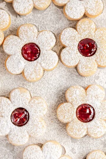 Pretty Linzer cookies, made in the shape of a daisy and filled with raspberry jam.