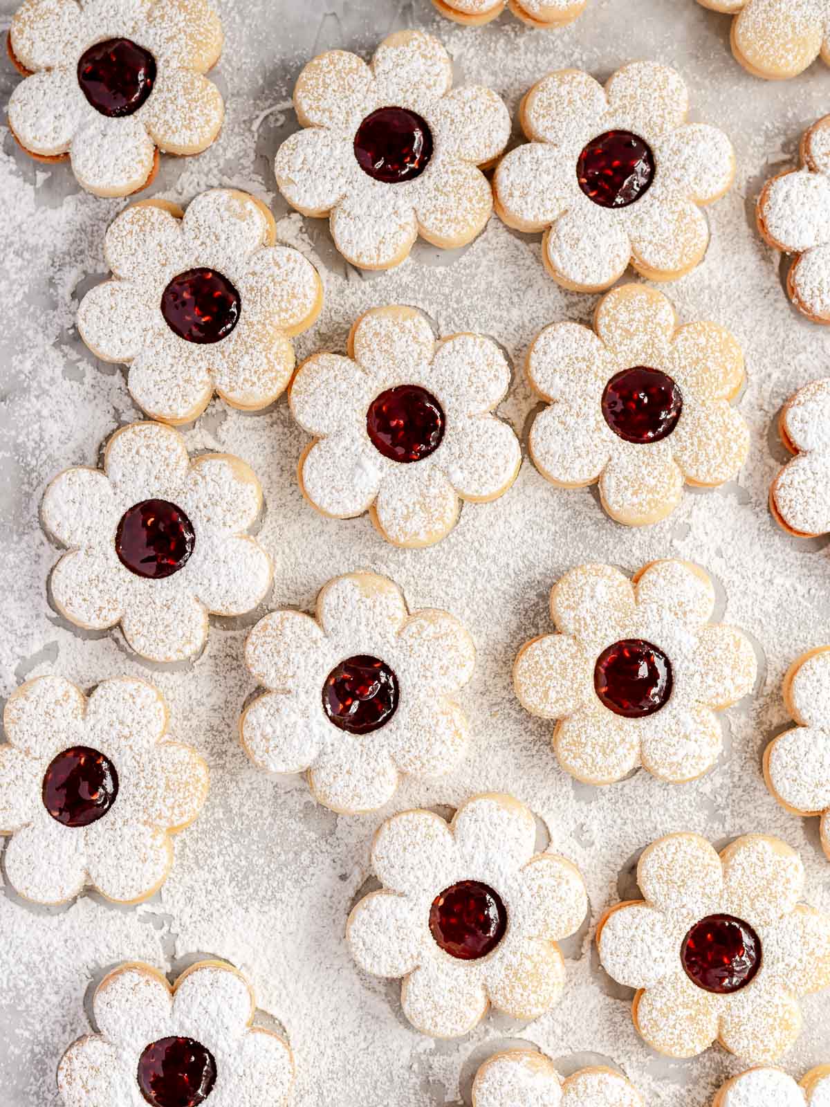 Raspberry Linzer cookies, dusted with icing sugar and filled with raspberry jam.