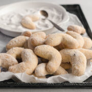 A tray of Austrian vanilla crescent cookies that have been coated in homemade vanilla sugar.