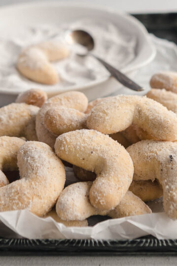 A tray of Austrian vanilla crescent cookies that have been coated in homemade vanilla sugar.