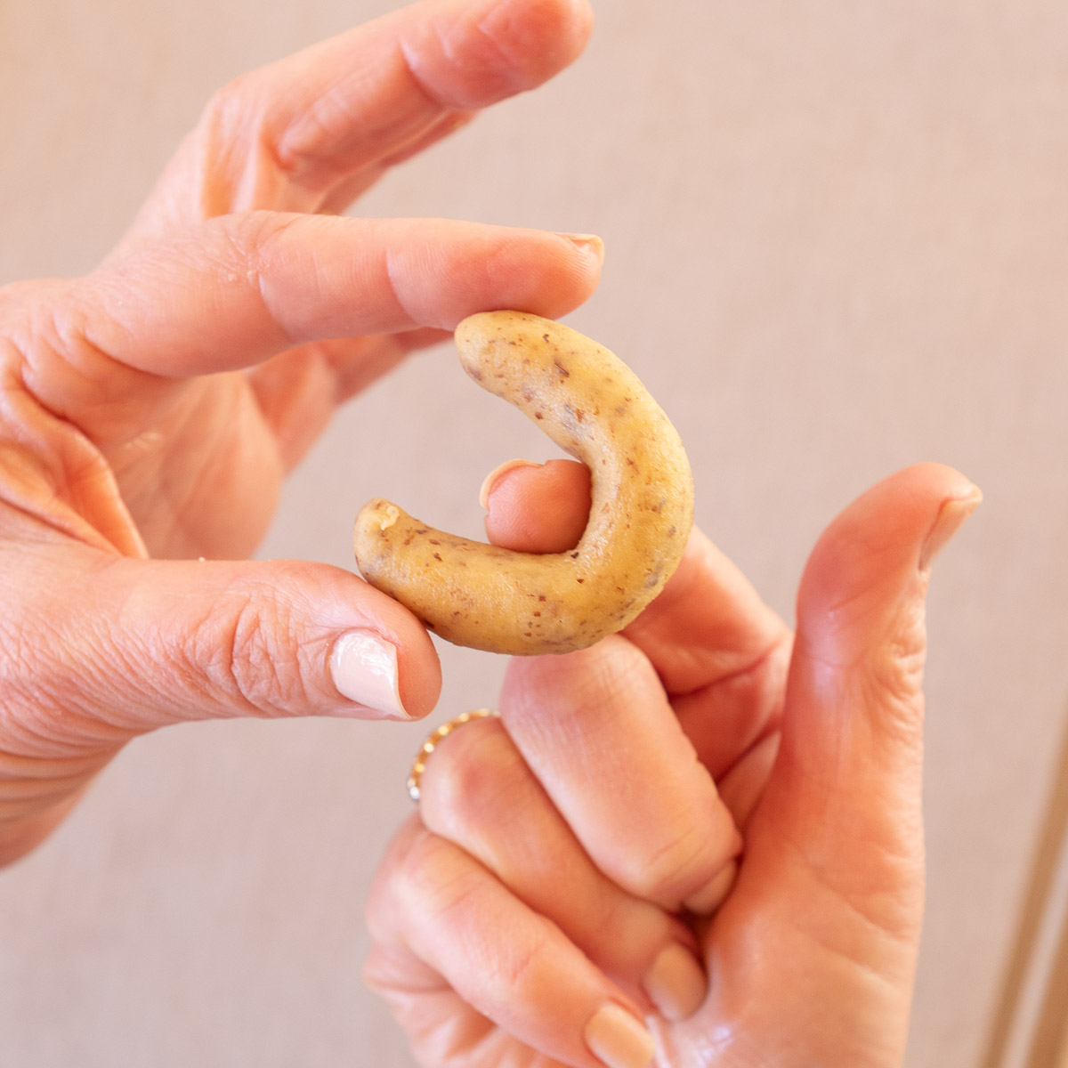Rolling the dough into crescents, to make Austrian vanilla crescent cookies.