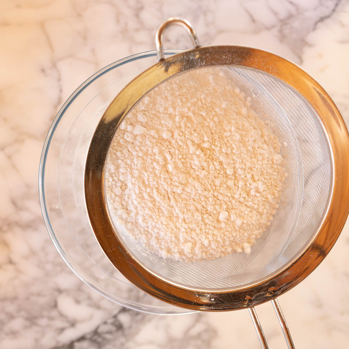 Sifting the dry ingredients to make Austrian shortbread cookies.