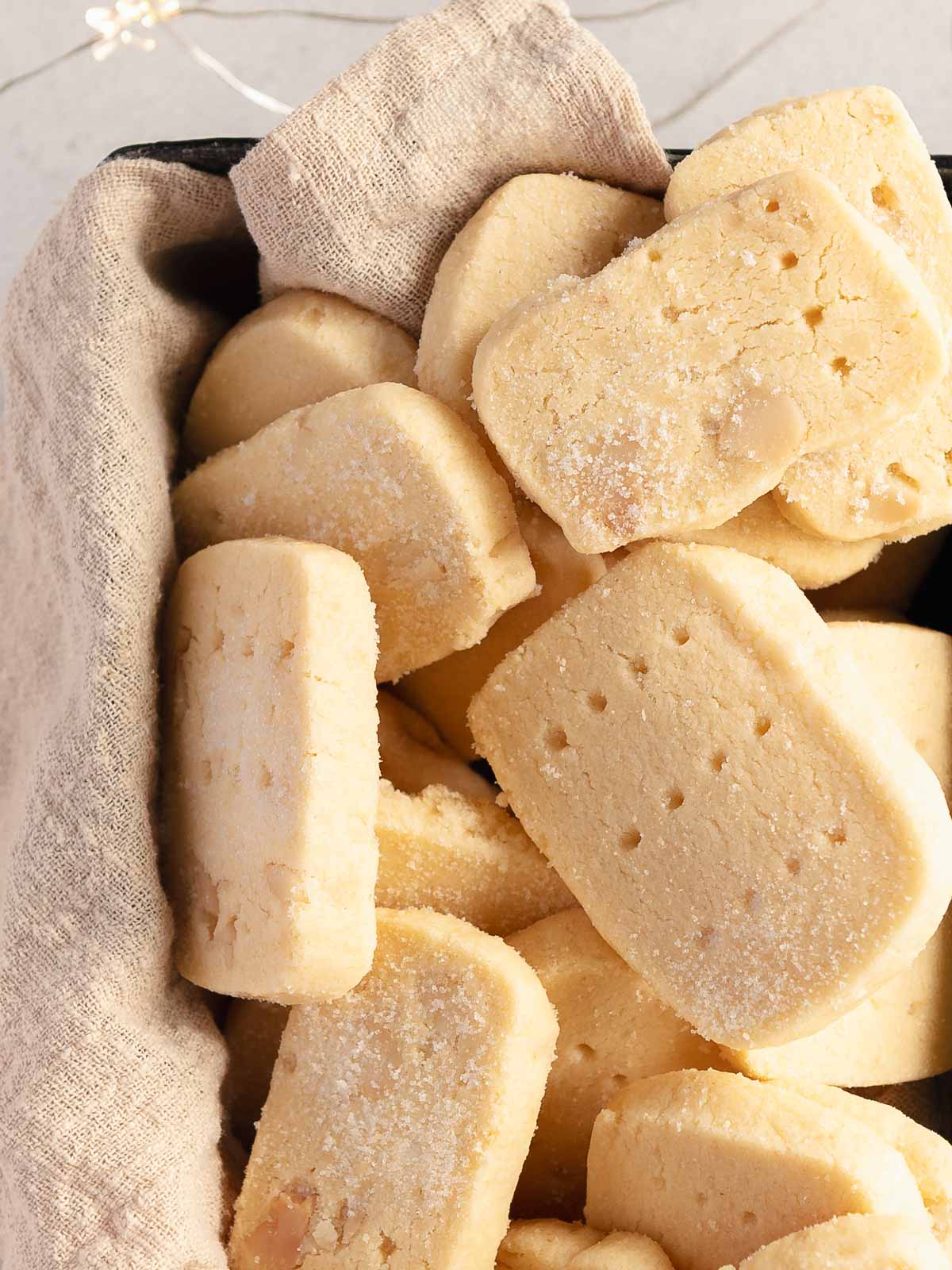 A container full of buttery homemade macadamia nut shortbread.