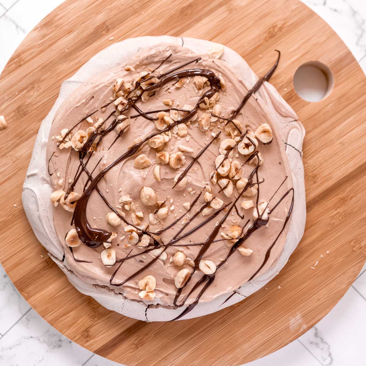 Layering the nutella pavlova stack with nutella cream.