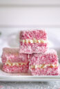 Homemade pink lamingtons filled with chantilly cream.