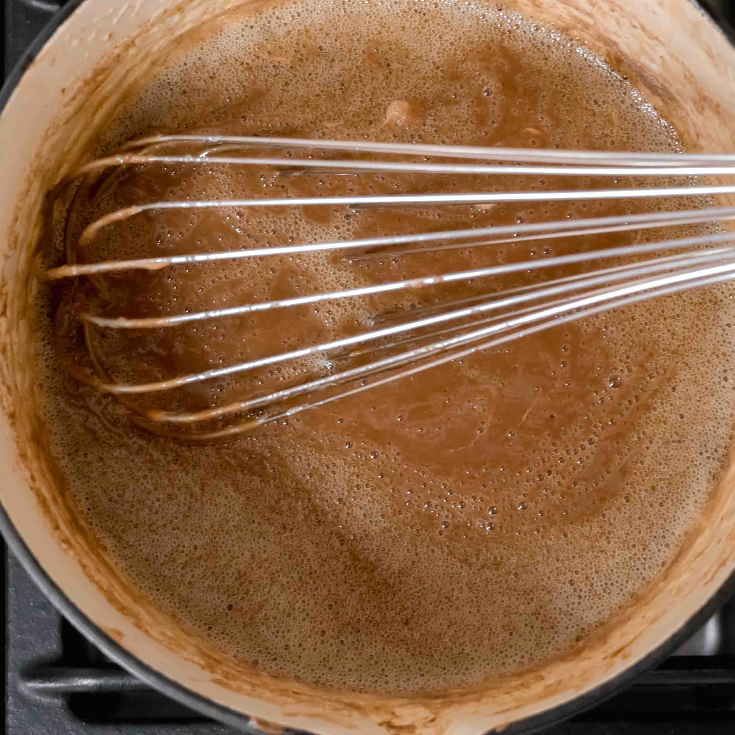 Using a balloon whisk to combine the mixture.